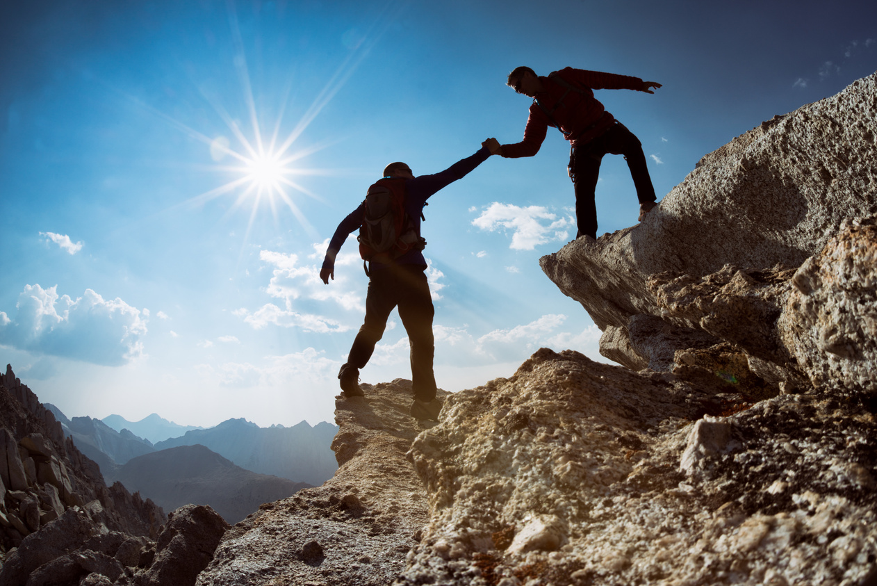 Friends climb a mountain together